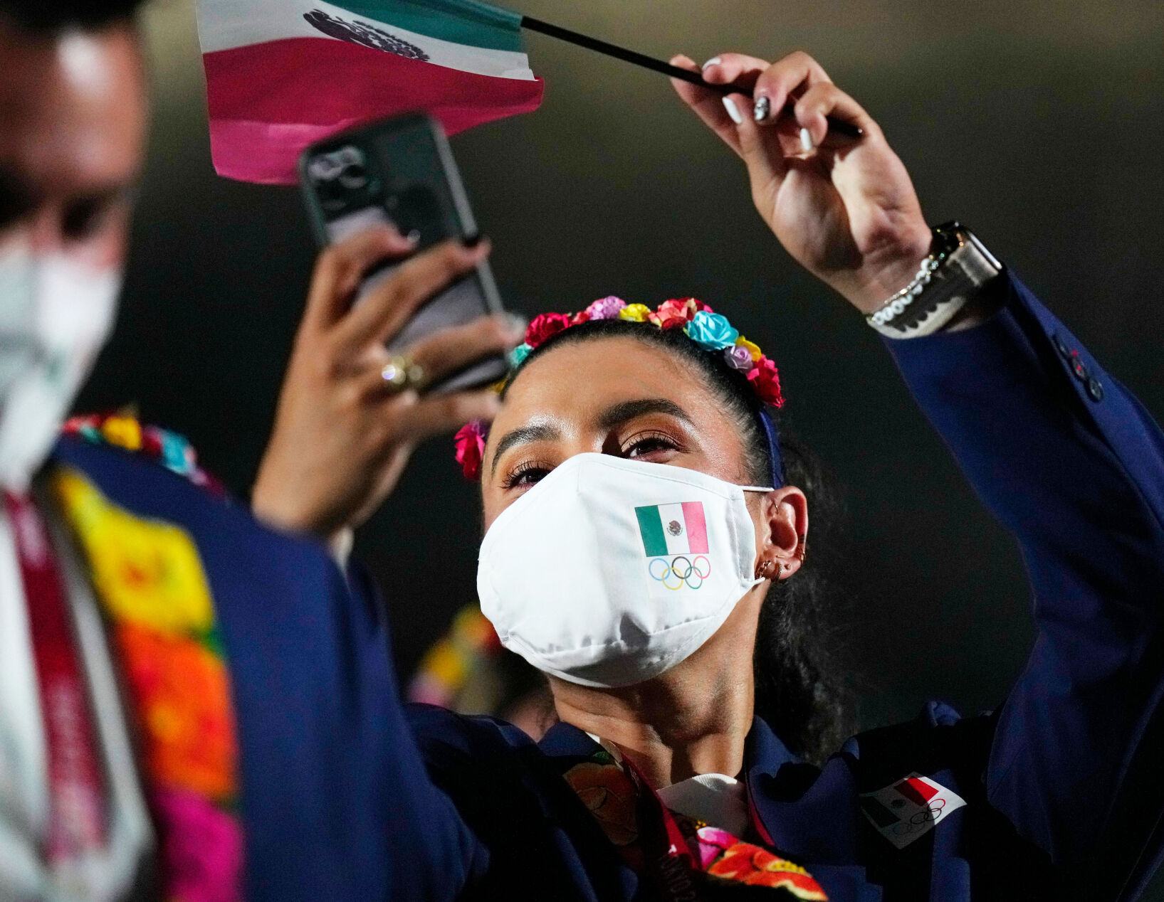 An athlete from Mexico waves a small flag